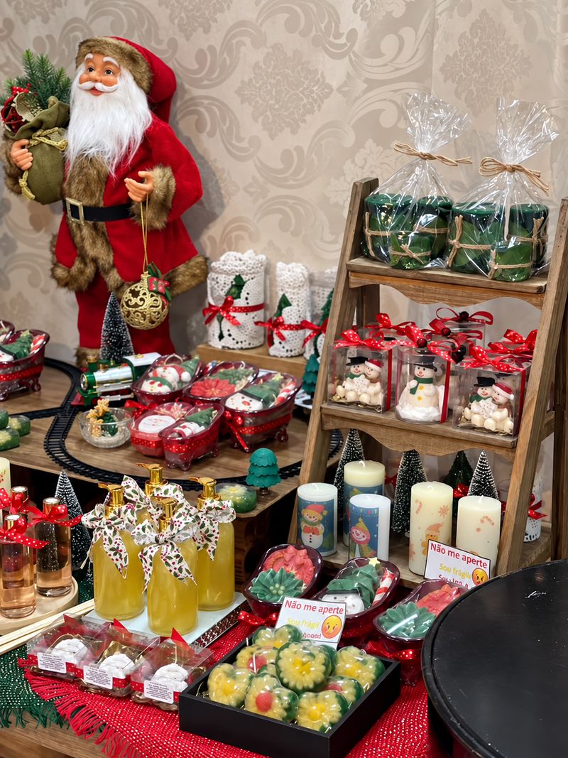 Vitrine de Natal com sabonetes decorados, velas e frascos de sabonete líquido com laços.