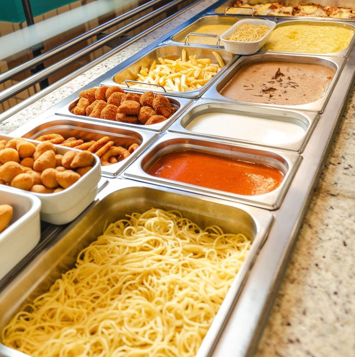 Buffet do Labuka com espaguete, molhos, batata frita e empanados em cubas de inox.