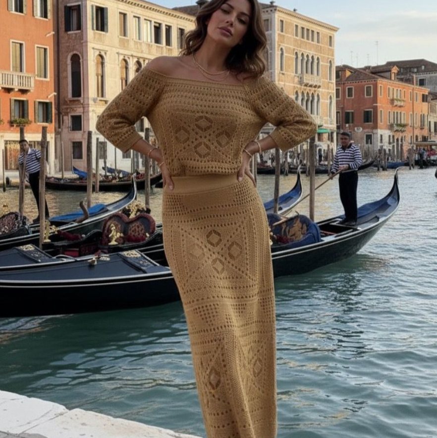 Mulher com conjunto de tricô caramelo, blusa ombro a ombro e saia longa, em frente a um canal com gôndolas.