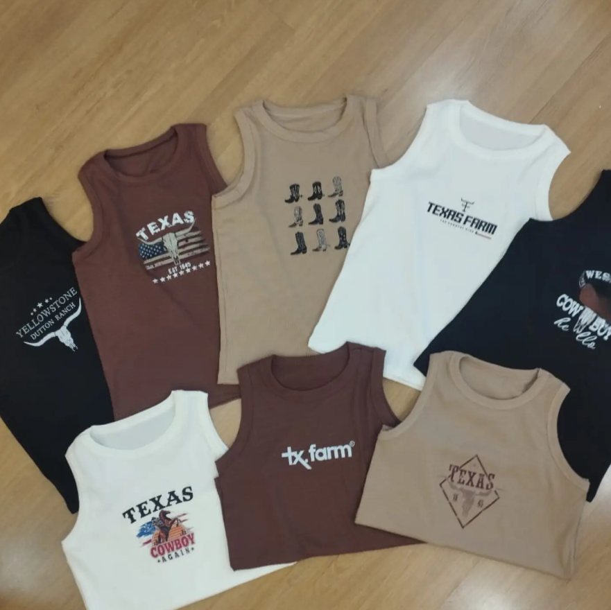 Regatas em marrom, bege, branco e preto com estampas de estilo western, dispostas sobre o chão de madeira.