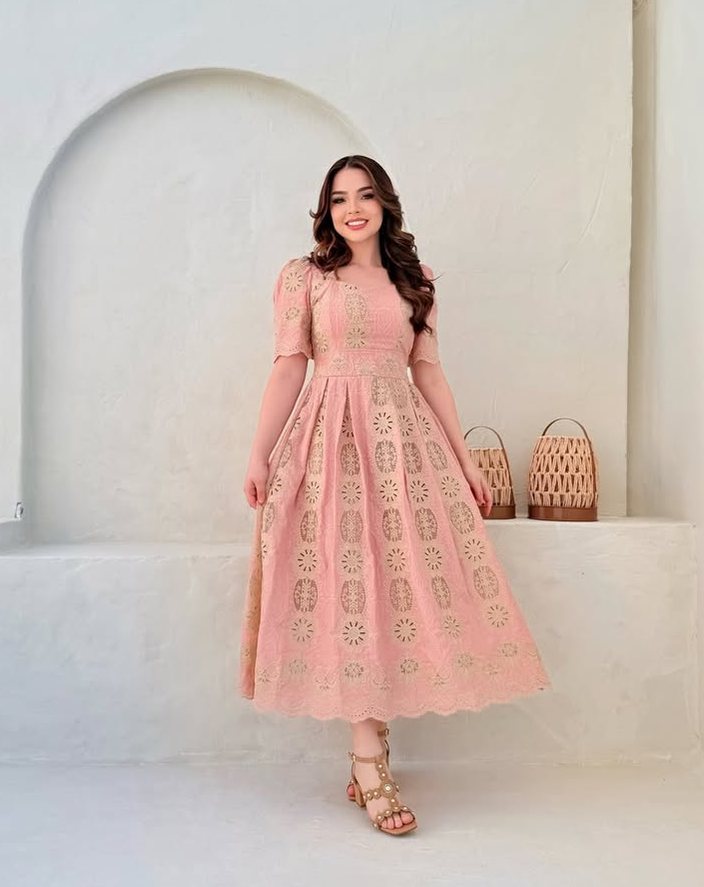 Mulher com vestido midi rosa de renda, manga curta bufante.