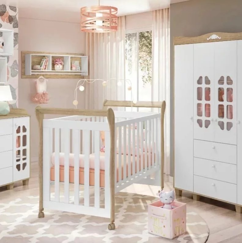 Quarto em tons de rosa, com berço branco e madeira clara, cômoda e guarda-roupa com detalhes recortados nas portas.
